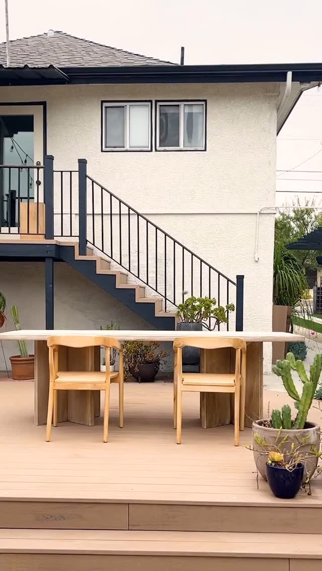 A finished low deck with wide steps, a railing, and an outdoor dining set at the back of a house, built by Concepts Construction