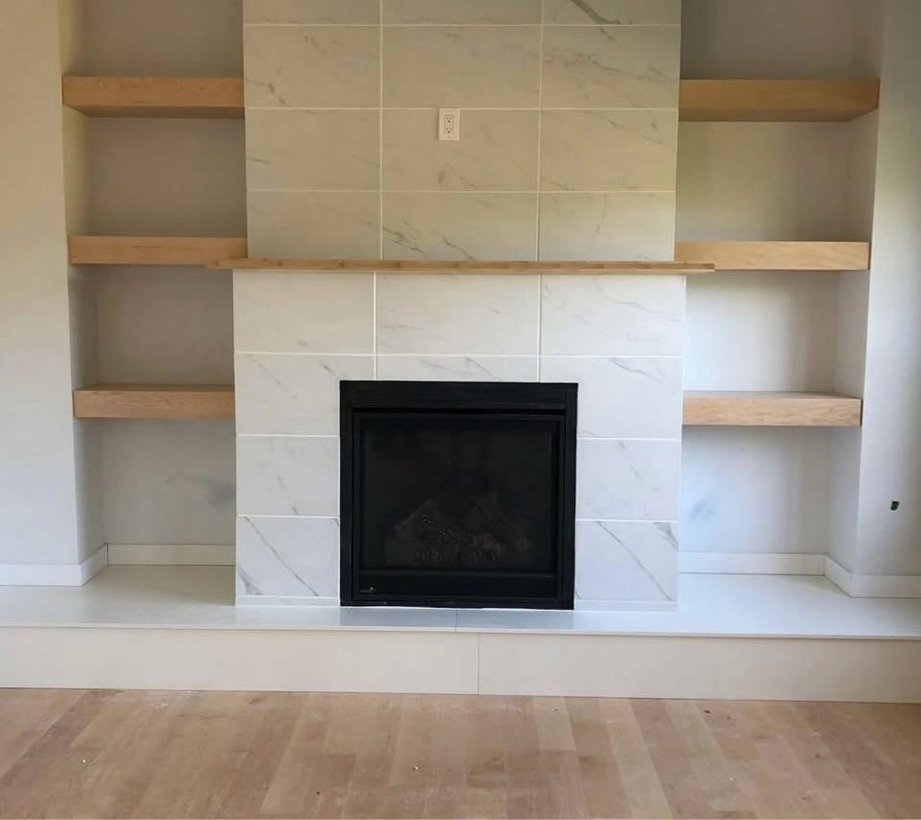 Marble-tile fireplace with floating shelves